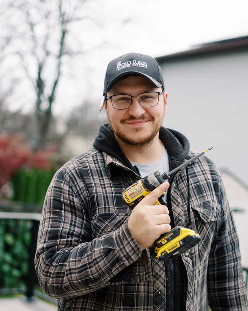 Phil Devine standing with a drill on an Ottawa deck project
