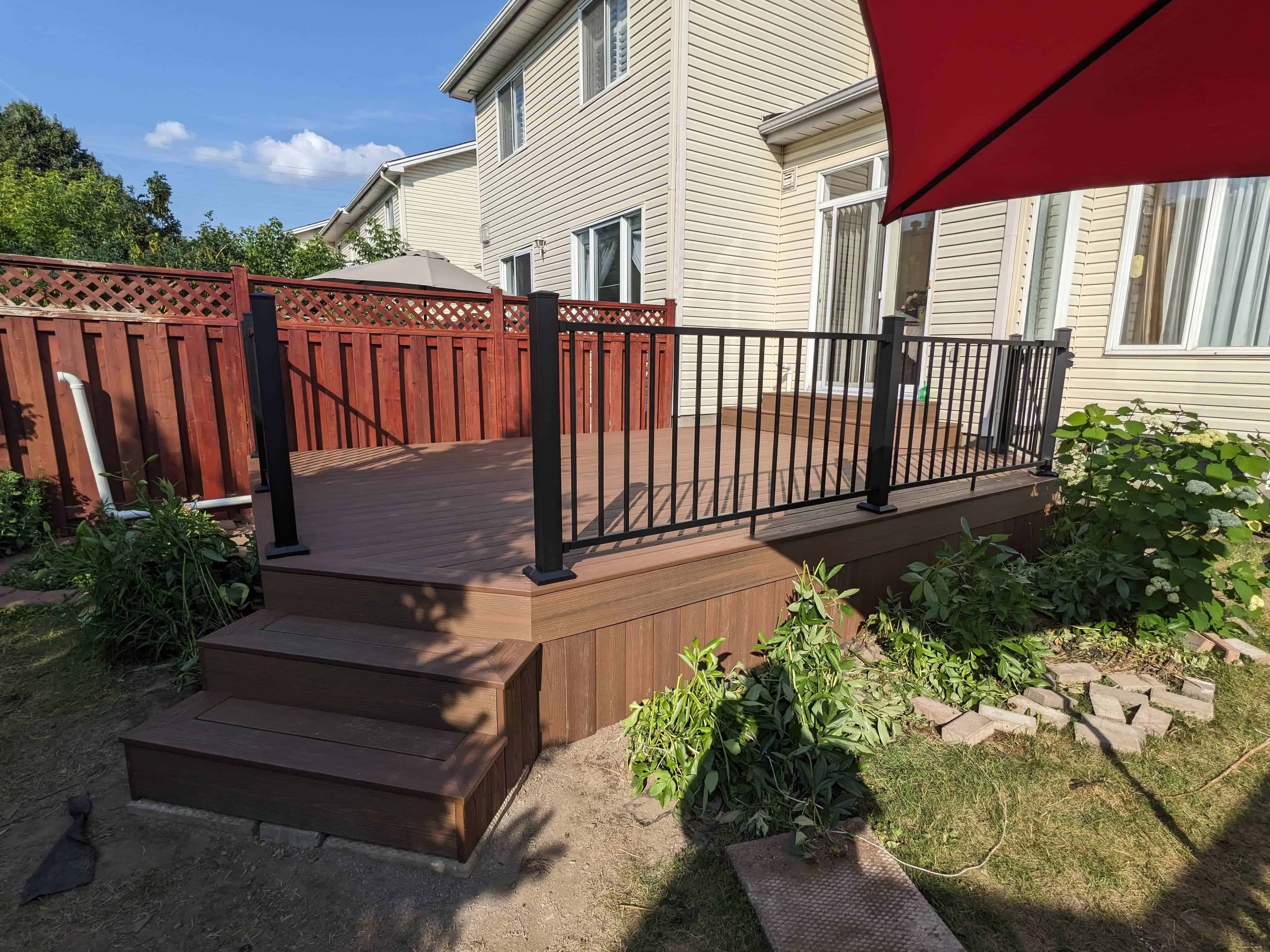 Finished custom deck with black railing by Ottawa Deck Builders